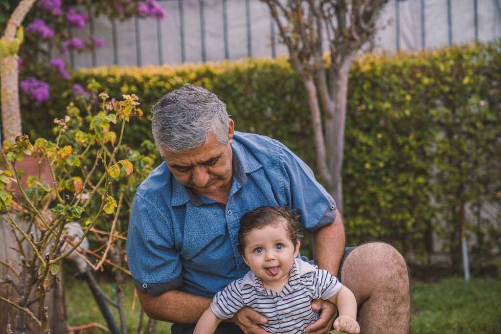 Man carrying baby in the garden